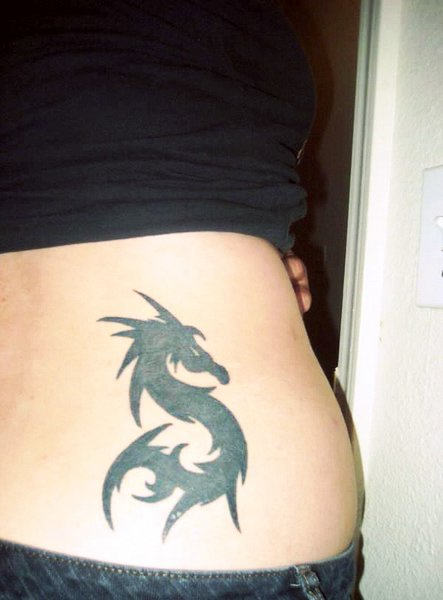 Wonderful Black Ink Tribal Dragon Tattoo On Women Lower Back