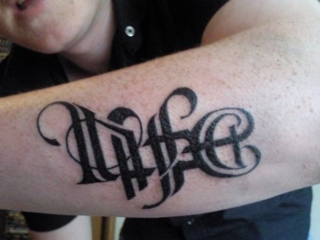 Black Ambigram Life Tattoo On Left Arm