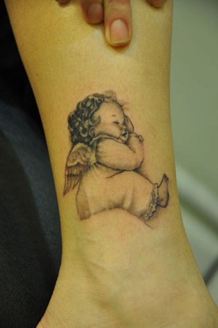 Black And Grey Baby Angel Tattoo On Ankle