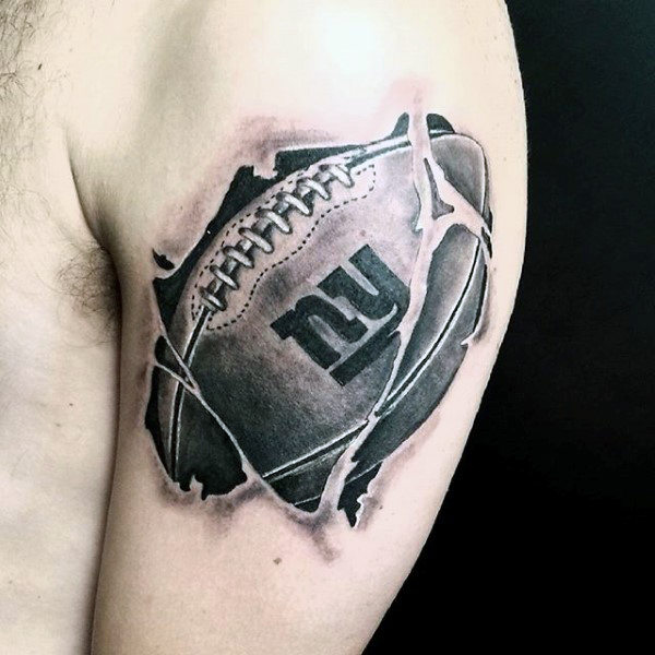 Black And Grey Ripped Skin Football Tattoo On Left Shoulder