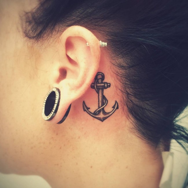 Black Ink Anchor Tattoo On Left Behind The Ear