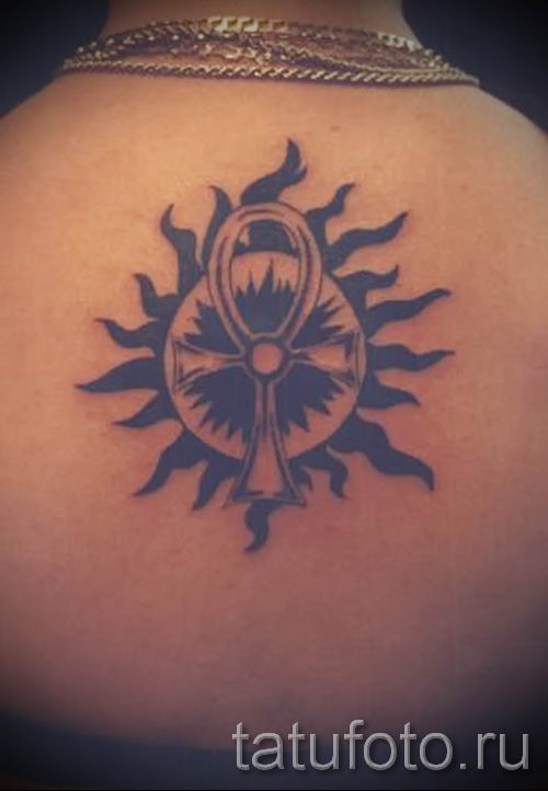 Black Ink Ankh With Sun Tattoo On Upper Back