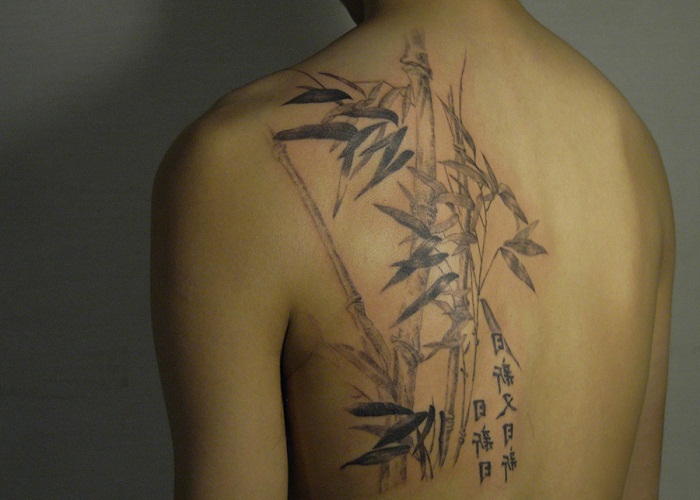 Black Ink Bamboo Tree Tattoo On Man Upper Back