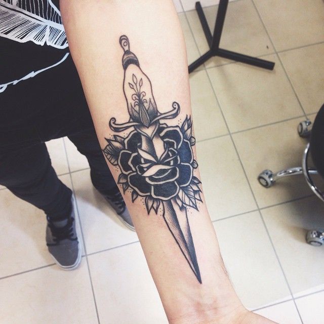 Black Ink Dagger In Rose Tattoo On Left Forearm