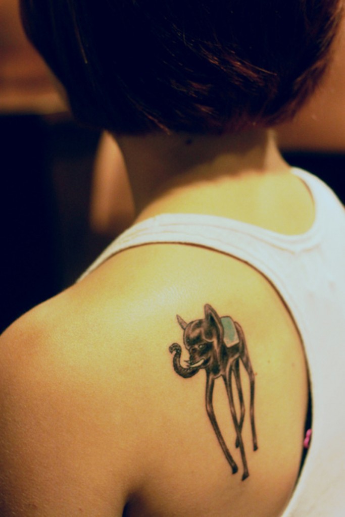 Black Ink Dali Elephant Tattoo On Left Back Shoulder