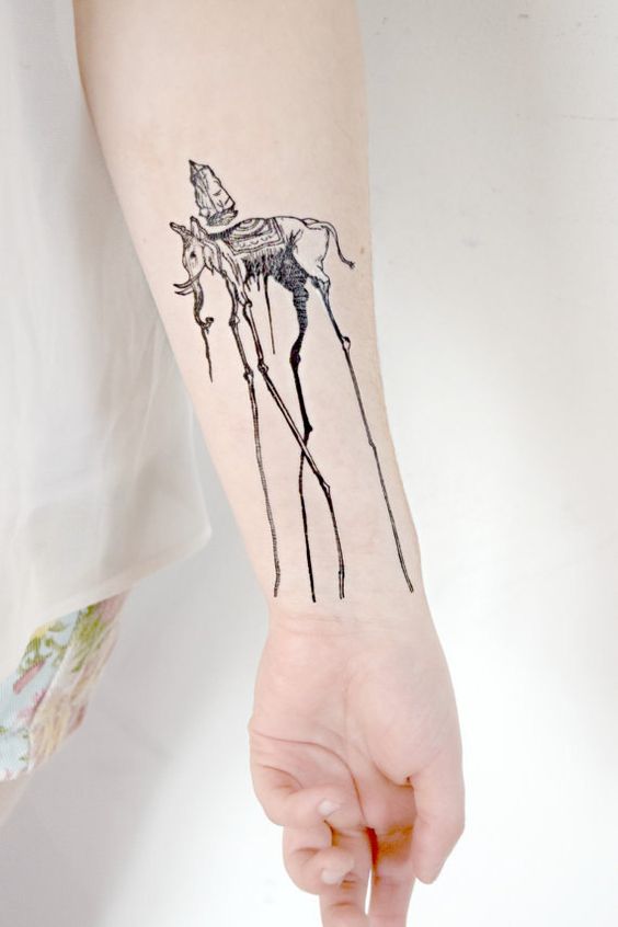 Black Ink Dali Elephant Tattoo On Left Forearm