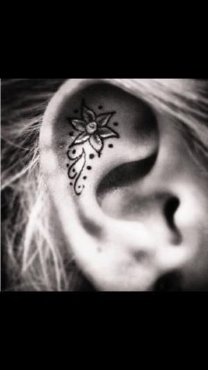 Black Ink Flower Tattoo On Right Ear