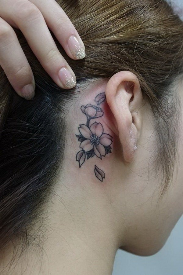 Black Ink Flowers Tattoo On Girl Right Behind The Ear