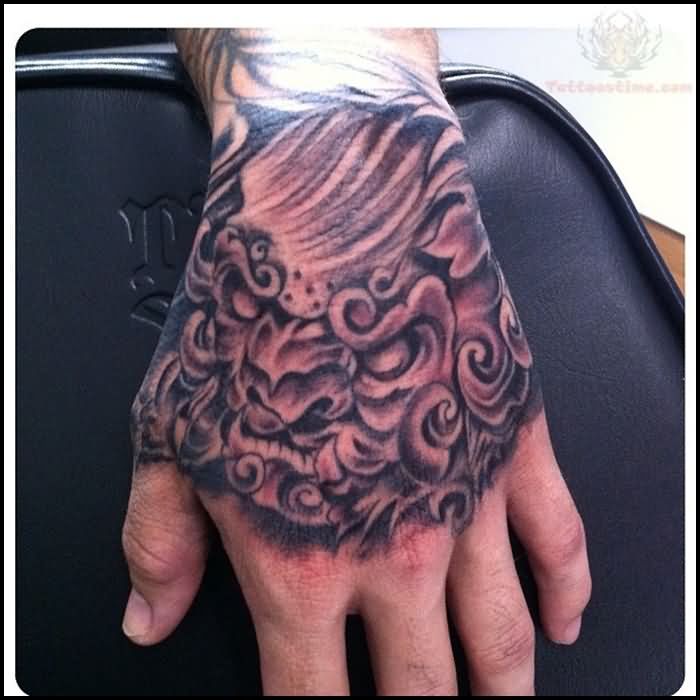 Black Ink Foo Dog Tattoo On Man Left Hand