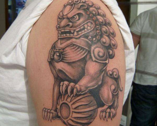 Black Ink Foo Dog Tattoo On Man Left Shoulder