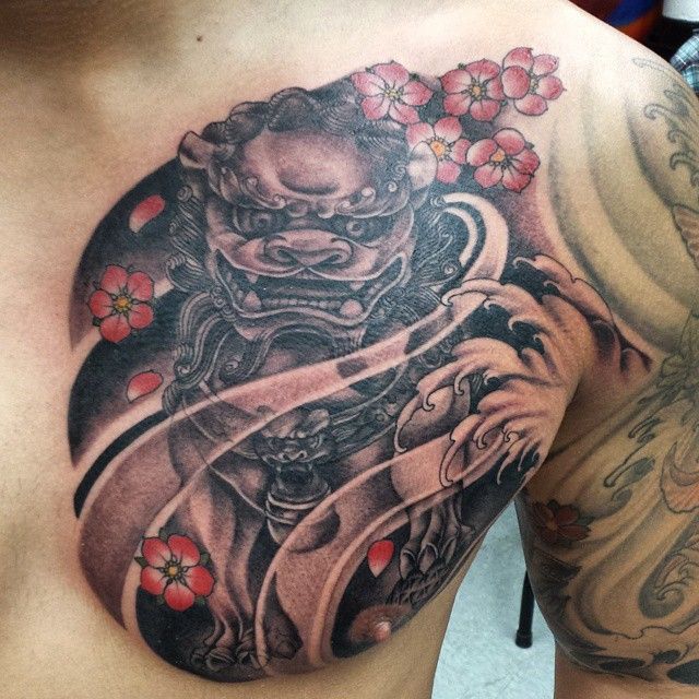 Black Ink Foo Dog With Flowers Tattoo On Man Left Chest