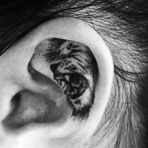 Black Ink Lion Tattoo On Left Ear