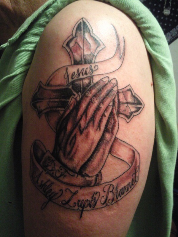 Black Ink Praying Hands With Cross And Banner Tattoo On Left Upper Arm
