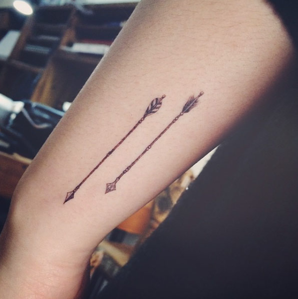 Black Ink Two Arrows Tattoo On Left Arm