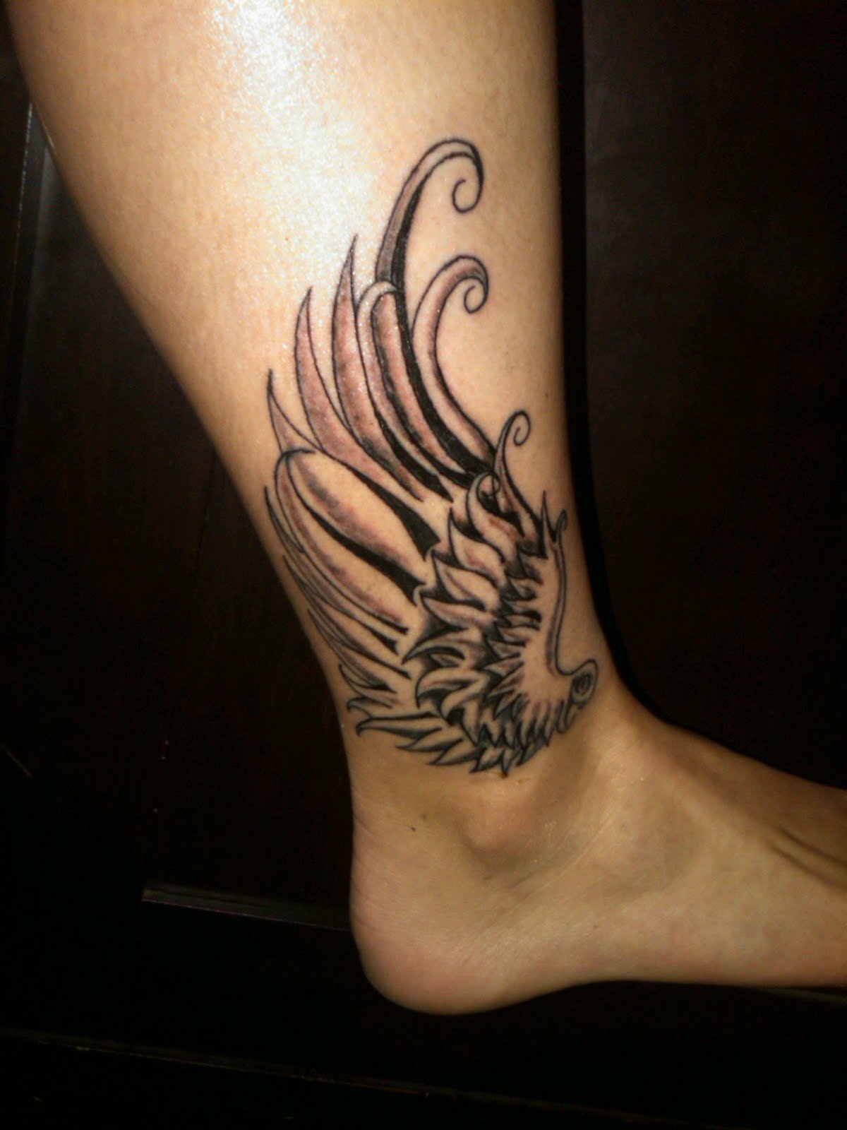 Black Ink Wing Tattoo On Right Ankle