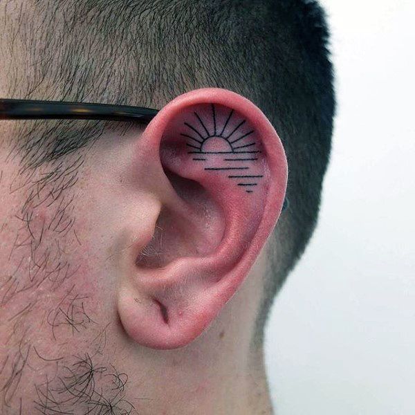 Black Outline Sun Tattoo On Man Left Ear