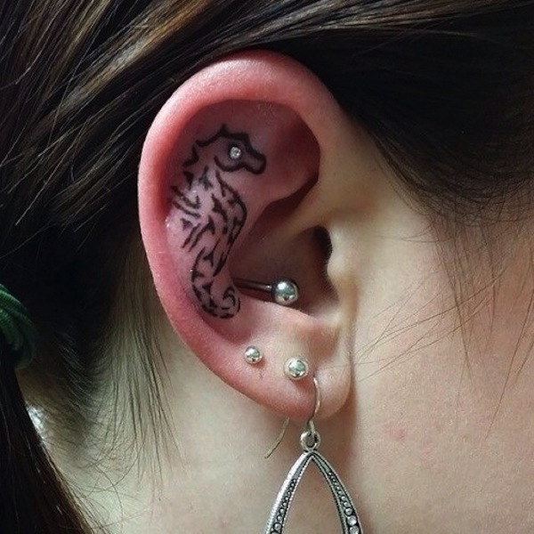 Black Tribal Seahorse Tattoo On Women Right Behind The Ear
