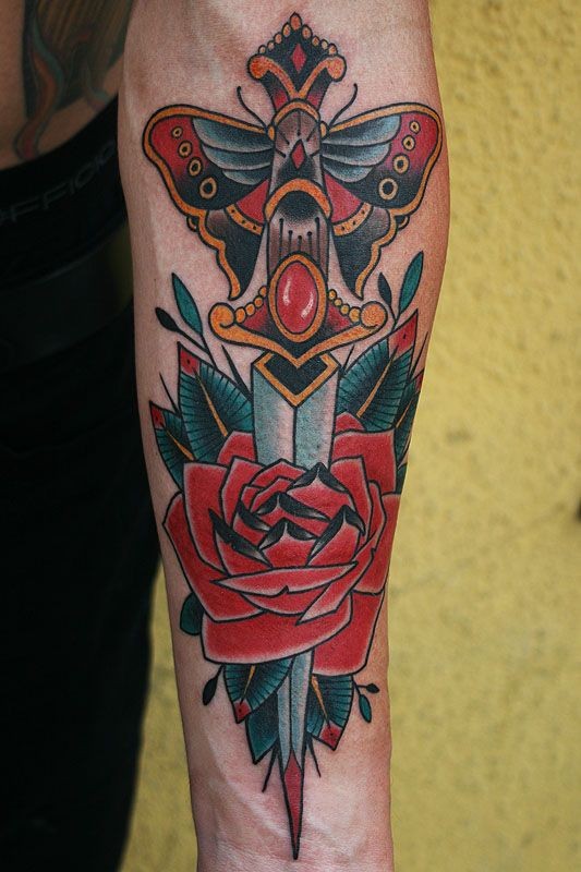 Colorful Traditional Dagger In Rose Tattoo On Left Forearm