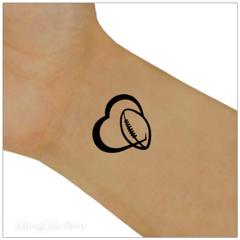 Cute Black Outline Heart With Football Tattoo On Wrist