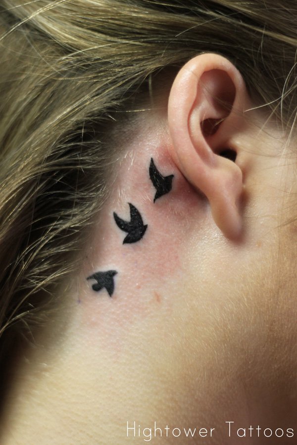 Silhouette Flying Birds Tattoo On Women Right Behind The Ear