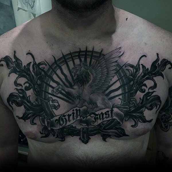 Black And Grey Griffin With Ship Wheel With Banner Tattoo On Man Chest