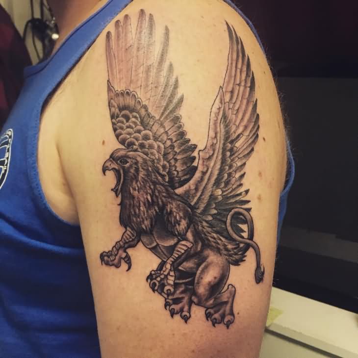 Black Ink Flying Griffin Tattoo On Man Left Shoulder