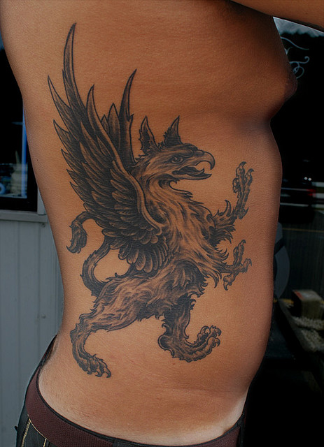 Black Ink Flying Griffin Tattoo On Man Right Side Rib
