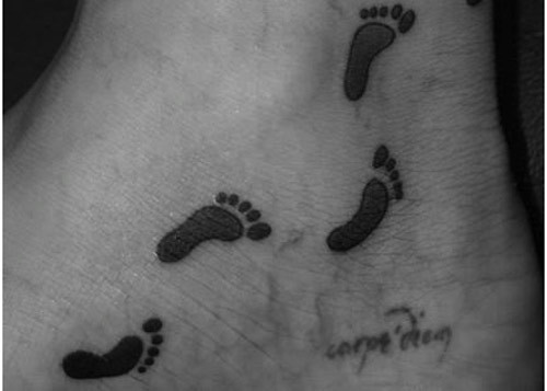 Black Ink Footprints Tattoo On Ankle