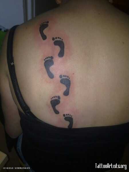 Black Ink Footprints Tattoo On Girl Left Back Shoulder