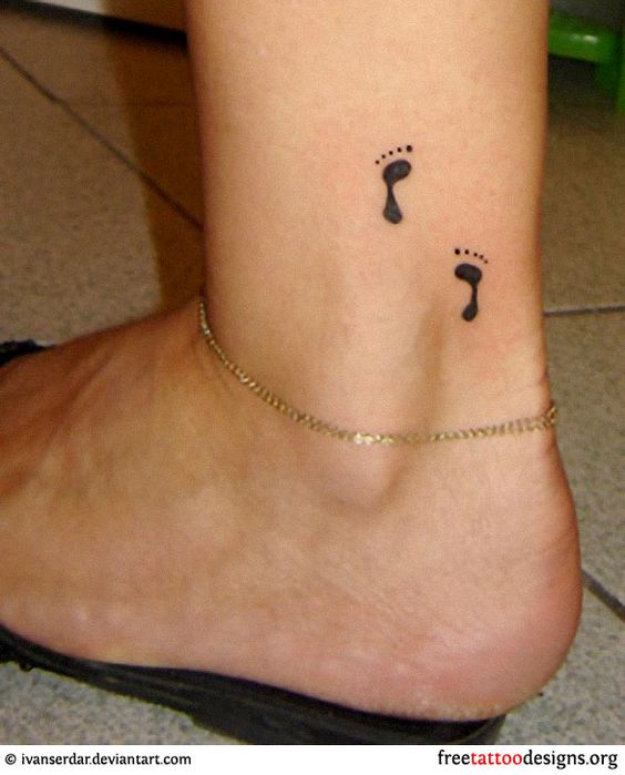 Black Ink Footprints Tattoo On Women Left Ankle