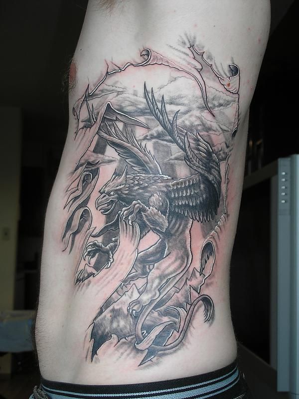 Black Ink Griffin Tattoo On Man Left Side Rib