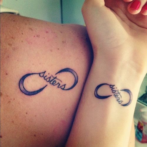 Black Ink Infinity With Sisters Lettering Tattoo On Right Back Shoulder And Wrist