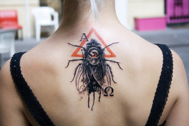 Black Ink Insect Tattoo On Women Upper Back