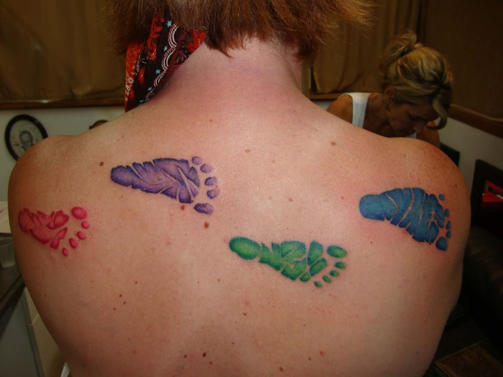 Colorful Footprints Tattoo On Upper Back