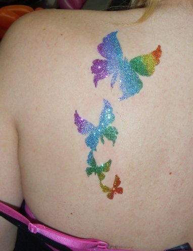 Colorful Glitter Flying Butterflies Tattoo On Girl Left Back Shoulder