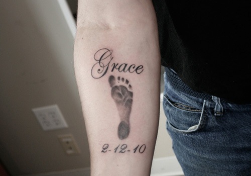 Grace – Memorial Black Ink Footprint Tattoo On Right Forearm