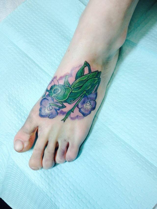 Green Ink Grasshopper With Flowers Tattoo On Left Foot