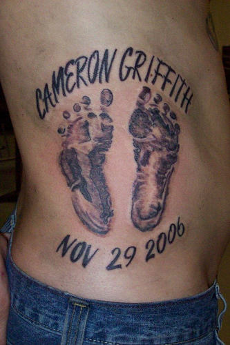 Memorial Black Ink Footprints Tattoo On Right Side Rib
