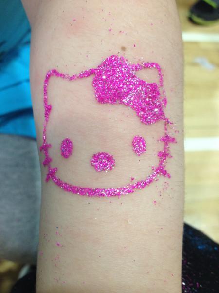 Pink Ink Glitter Hello Kitty Head Tattoo On Forearm