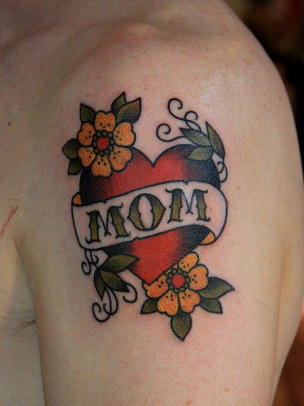 Traditional Heart With Flowers And Mom Banner Tattoo On Man Left Shoulder