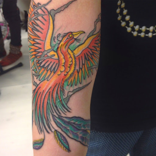 Colorful Flying Phoenix Tattoo On Man Right Sleeve
