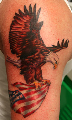 Eagle Flying With American Flag In Claws Tattoo On Shoulder