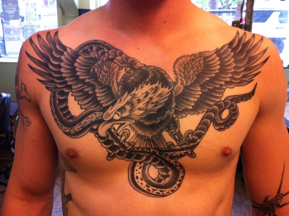 Eagle Flying With Snake In Beak Tattoo On Man Chest