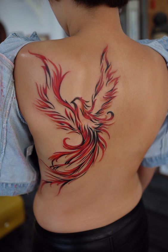 Nice Tribal Black And Orange Ink Flying Phoenix Tattoo On Full Back