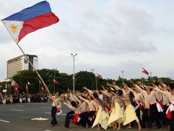 A performer holds a Philippine flag during the Independence Day celebrations at the Quirino Grandstand in Manila