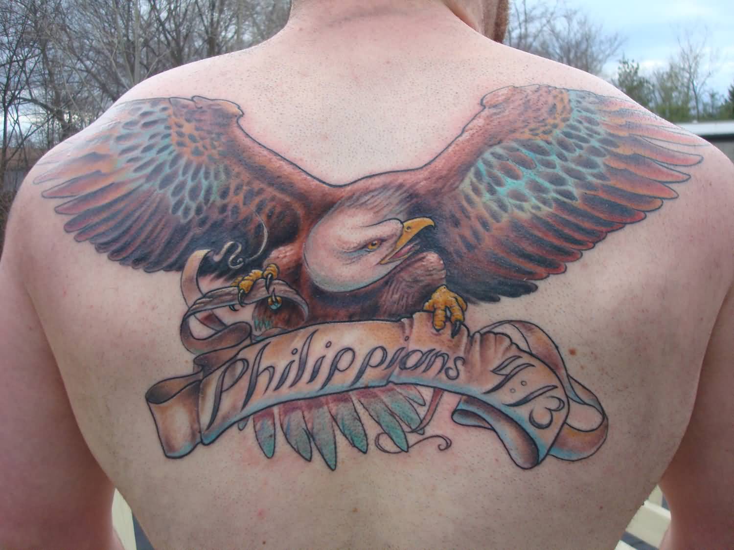 Realistic Flying Eagle With Philipians Banner Tattoo On Man Upper Back