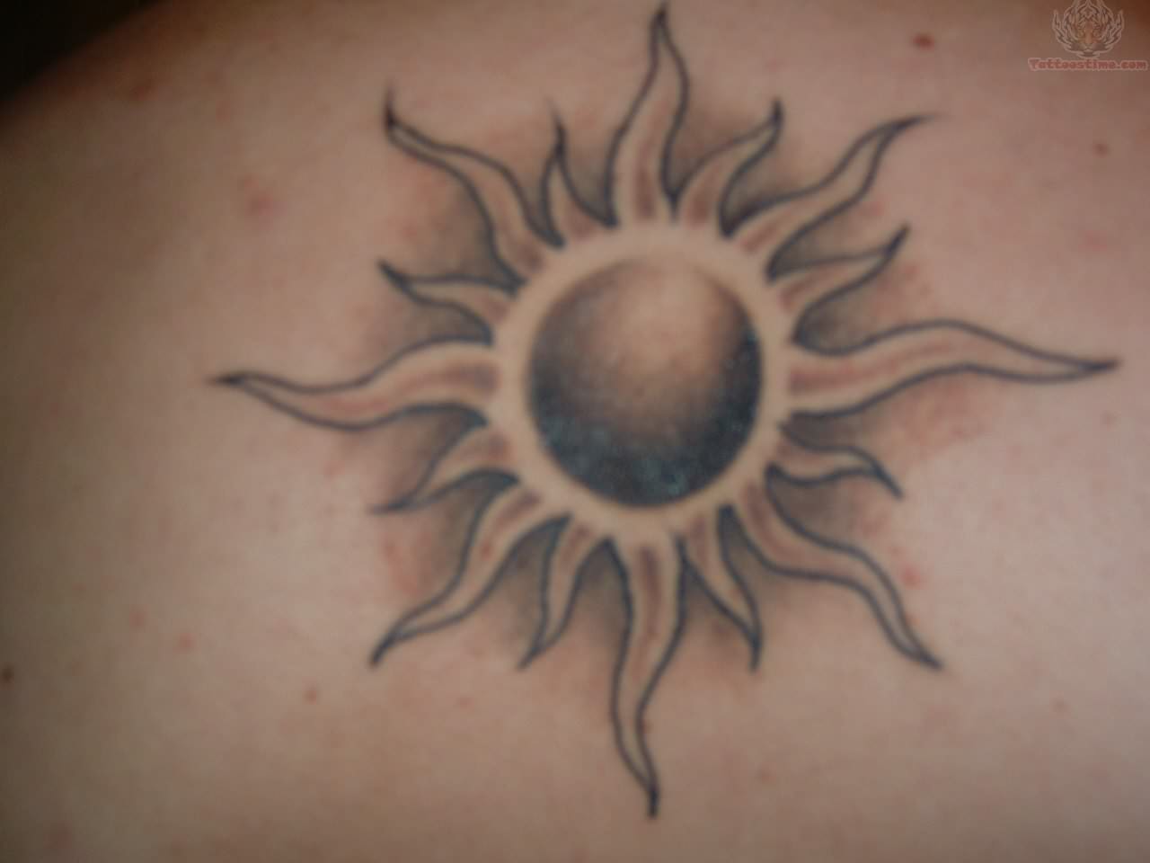 Black And Grey Sun Tattoo On Shoulder