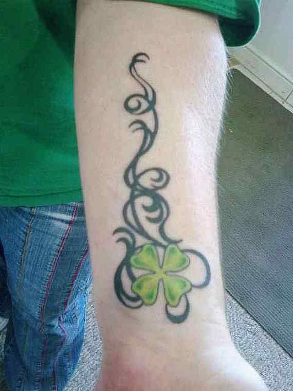 Black Tribal And Green Shamrock Leaf Tattoo On Left Forearm