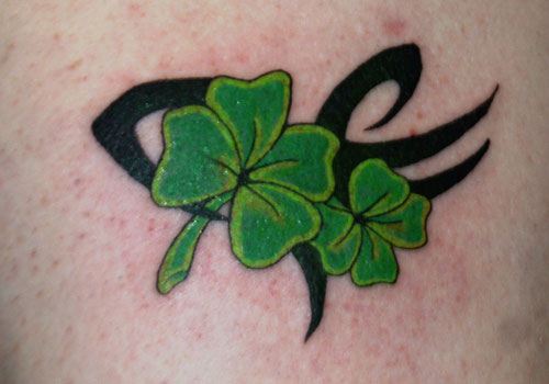 Black Tribal And Green Shamrock Leaves Tattoo