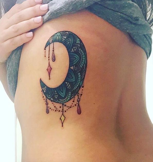 Blue And Black Crescent Moon Tattoo On Girl Side Rib